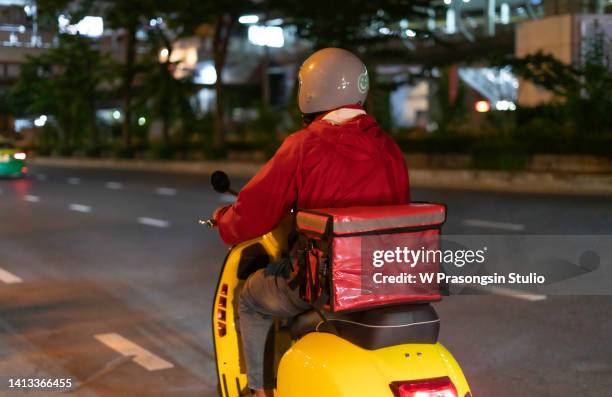 young man delivering food at night - distrito municipal tipo de distrito fotografías e imágenes de stock