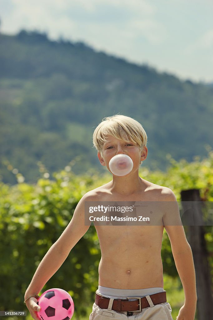 Smiling boy blowing bubble outdoors