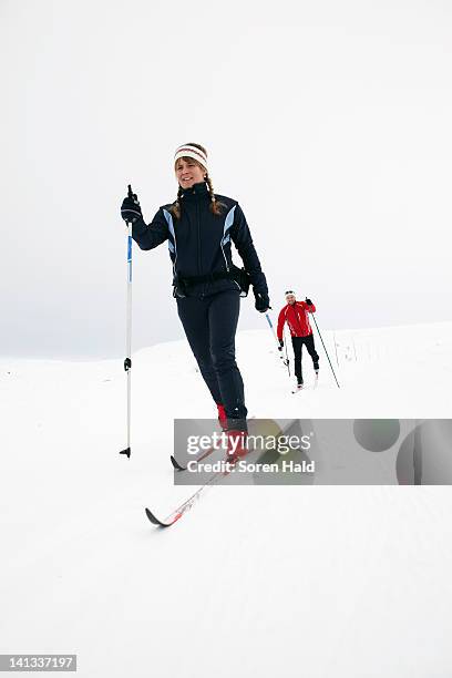 couple cross-country skiing in snow - cross country ski stock pictures, royalty-free photos & images