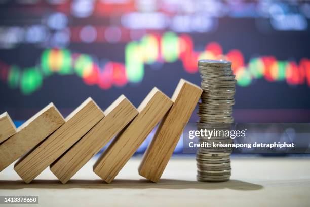 money coins heap still balance and stop the falling domino, financial stability concept,stock market concept. - impacto fotografías e imágenes de stock