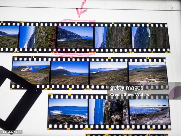 35mm transparency film strips on a lightbox with a slide mount. - durchlocht stock-fotos und bilder