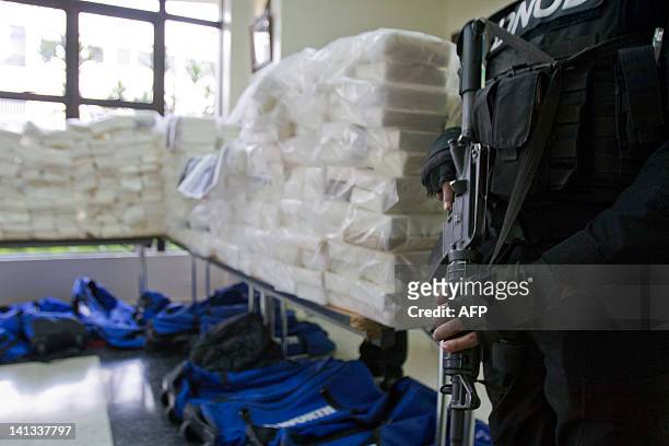 Dominican drug squad policemen stand guard next to packs containing 807,4 kilos of cocaine, confiscated by Dominican Drugs Control National Direction...