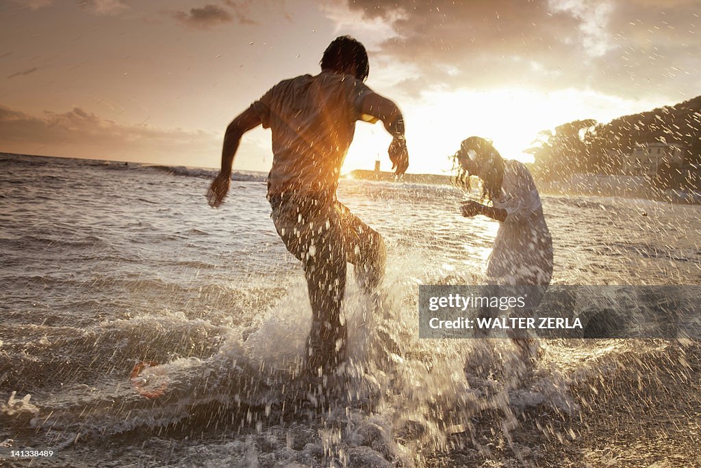 Couple playing in waves at beach