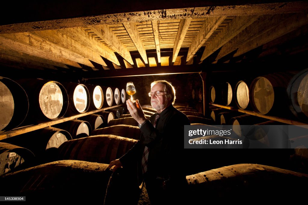 Worker testing whisky in distillery