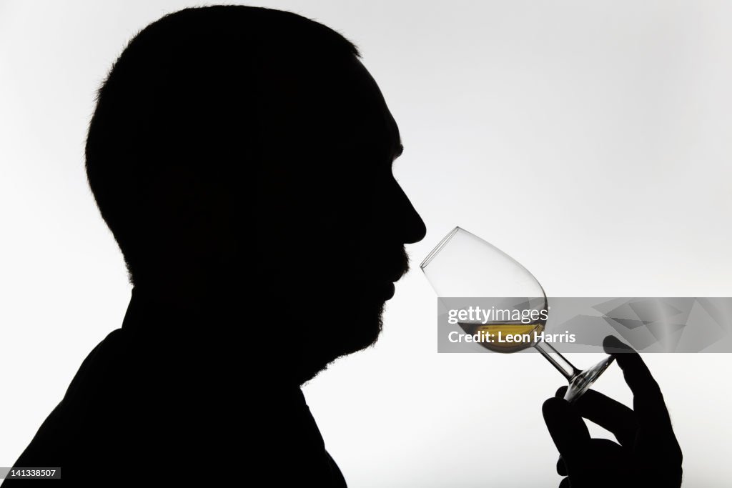 Worker smelling whisky in distillery