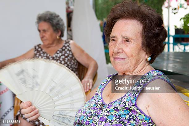 mujer de edad avanzada fanning misma al aire libre - calentador fotografías e imágenes de stock