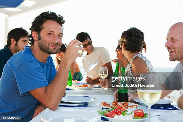 friends drinking at table outdoors - caprese stockfoto's en -beelden