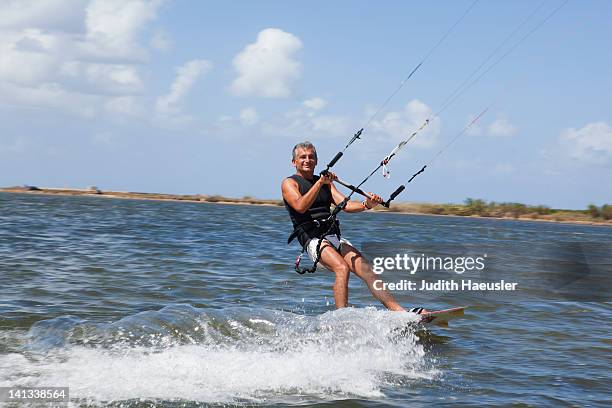 anziani uomo windsurf sul lago di - kite foto e immagini stock