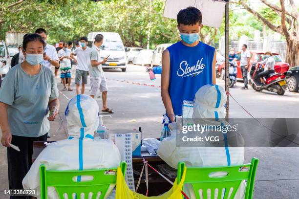 People queue up for COVID-19 nucleic acid tests on August 7, 2022 in Sanya, Hainan Province of China.