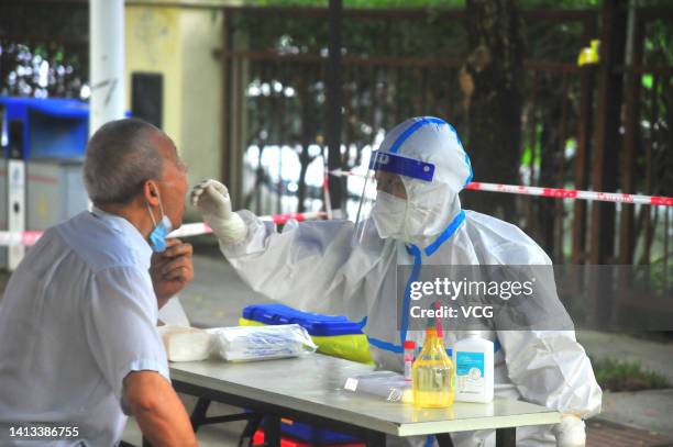 Medical worker takes swab sample from a resident for COVID-19 nucleic acid test on August 7, 2022 in Sanya, Hainan Province of China.