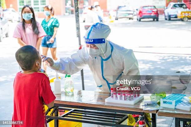 Medical worker takes swab sample from a child for COVID-19 nucleic acid test on August 7, 2022 in Sanya, Hainan Province of China.