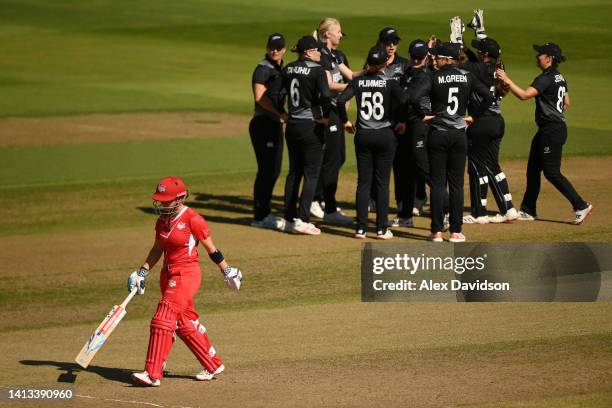 Alice Capsey of Team England looks dejected after being dismissed as Team New Zealand celebrate during the Cricket T20 - Bronze Medal match between...