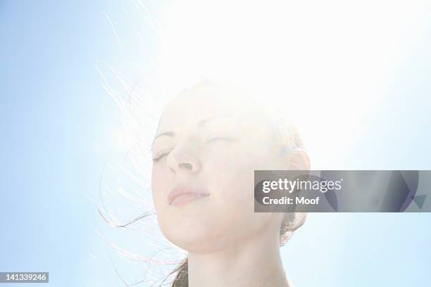 sonriendo womanâ  s face contra el cielo azul - eyes closed fotografías e imágenes de stock