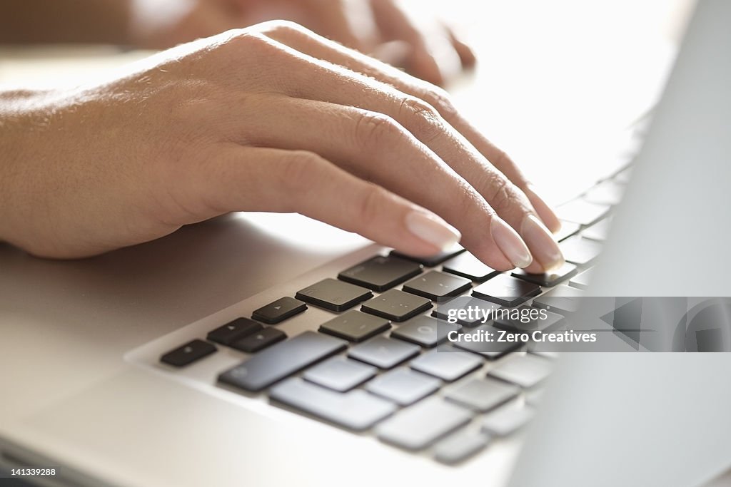 Close up of woman typing on laptop