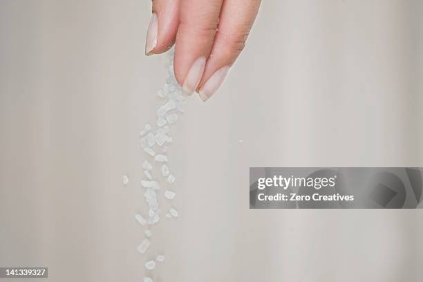 close up of woman sprinkling salt - sprinkling ストックフォトと画像