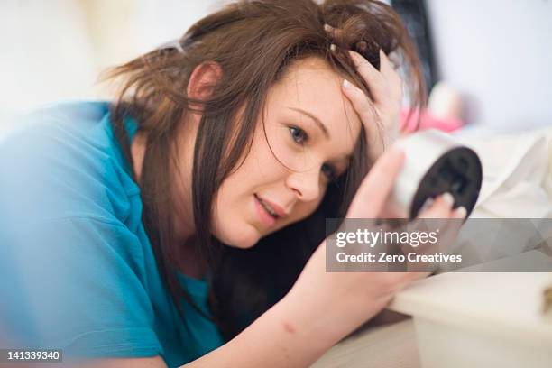 teenage girl checking alarm clock - overslept stockfoto's en -beelden