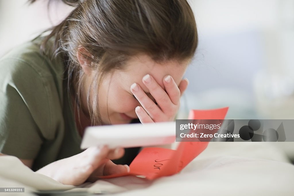 Crying teenage girl reading letter