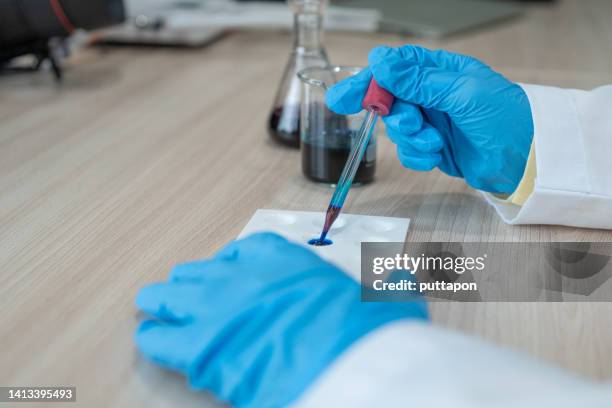 female scientist biochemists are testing nalyzing sample in test tube is experimenting in lab - patholoog stockfoto's en -beelden