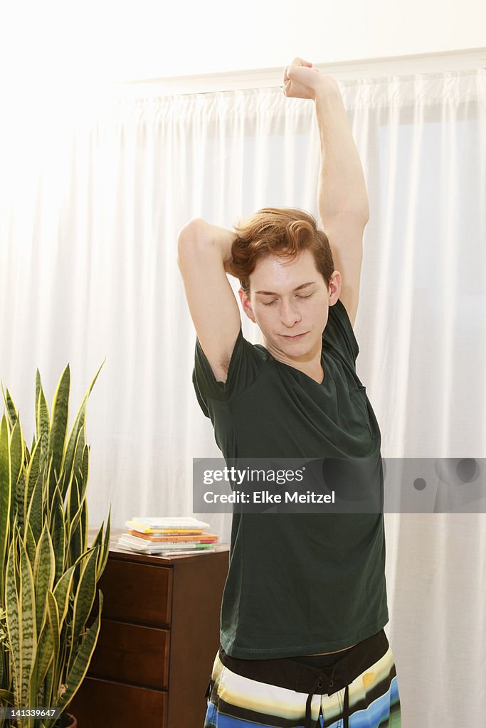 Man stretching in bedroom