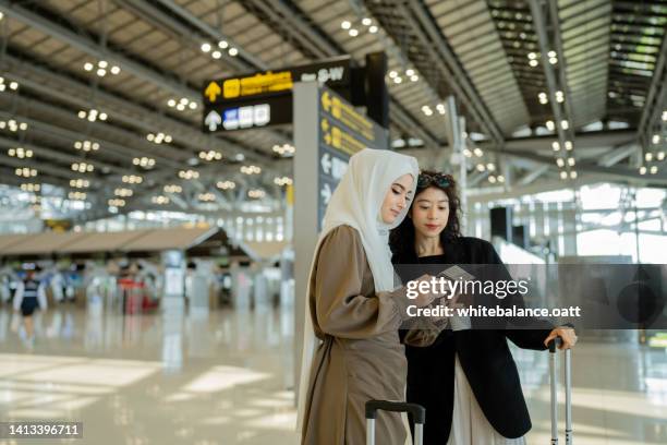 dos mujeres de negocios llegan al aeropuerto. - encontro social fotografías e imágenes de stock