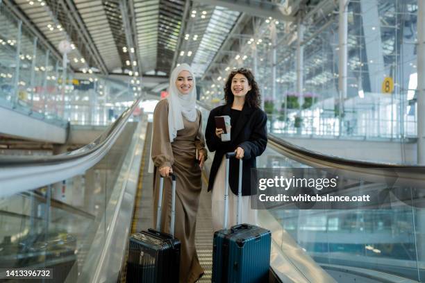 dos mujeres de negocios llegan al aeropuerto. - encontro social fotografías e imágenes de stock