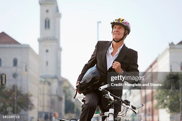 businessman with bicycle on city street - münchen business stock pictures, royalty-free photos & images