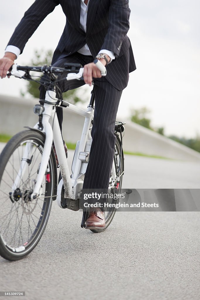 Businessman riding bicycle in urban park