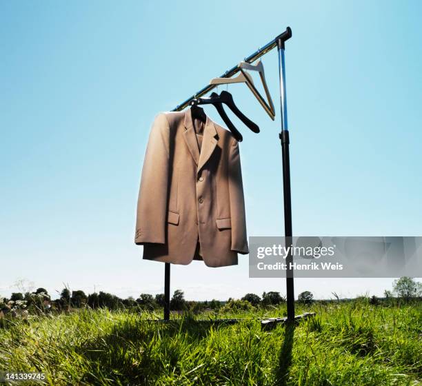 suit jacket hanging in field - suit jacket stock pictures, royalty-free photos & images