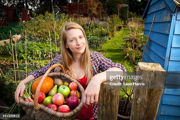 woman gathering vegetables in garden - mujer and manzana and frontal fotografías e imágenes de stock