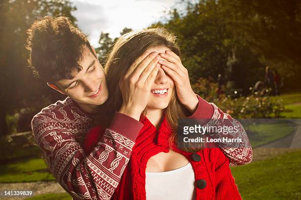 man covering girlfriends eyes in park - romance cover stock pictures, royalty-free photos & images