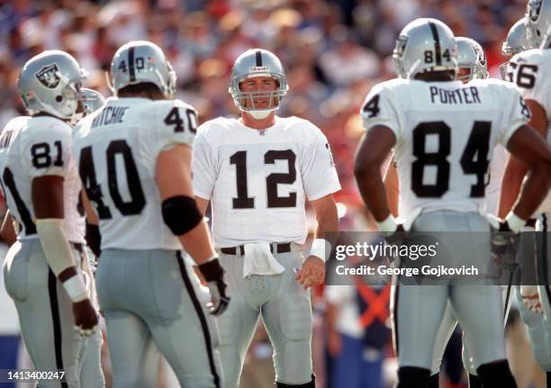 Quarterback Rich Gannon of the Oakland Raiders huddles with the offense including wide receivers Tim Brown and Jerry Porter and fullback Jon Ritchie...
