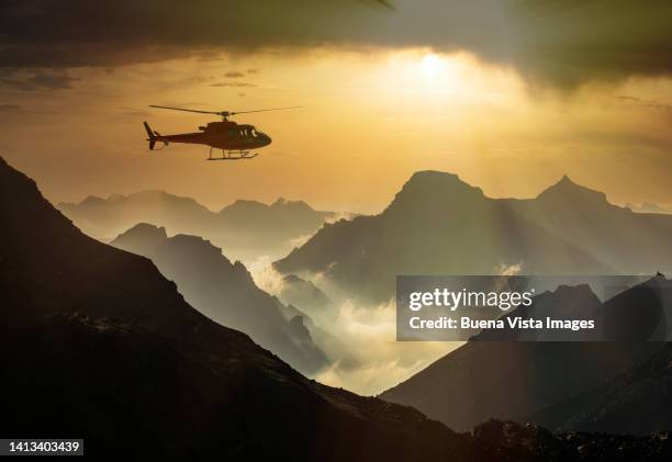 helicopter flying over mountains at sunset - monte rosa stock pictures, royalty-free photos & images