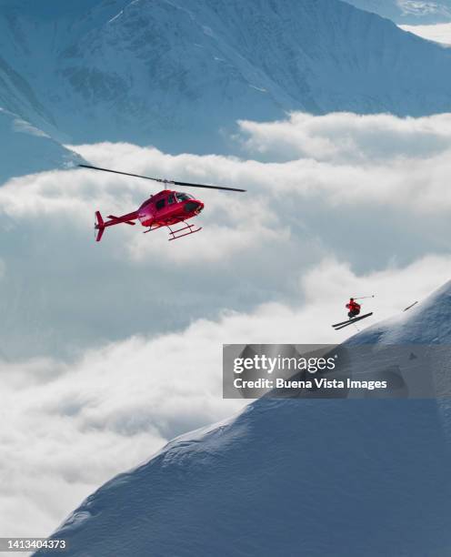 helicopter flying over a skier - heli skiing stock pictures, royalty-free photos & images