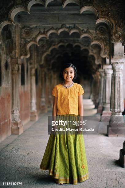 portrait of a cute girl wearing indian traditional dress standing in an old artistic stone temple. - 民族衣装 ストックフォトと画像