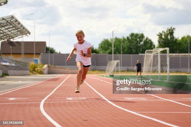 young girl running at athletic stadium - girls on train track stock pictures, royalty-free photos & images