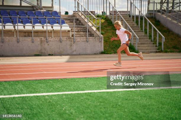 young girl running at athletic stadium - stadium general view stock pictures, royalty-free photos & images