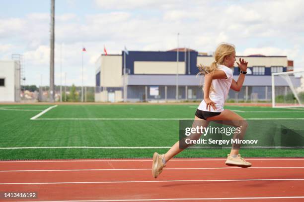 young girl running at athletic stadium - stadium general view stock pictures, royalty-free photos & images