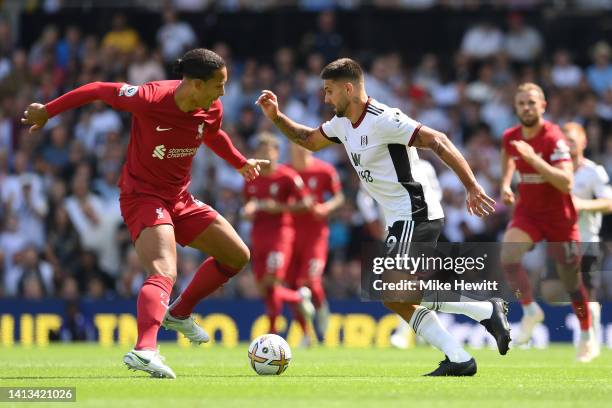 Roberto Firmino of Liverpool is challenged by Virgil van Dijk of Liverpool during the Premier League match between Fulham FC and Liverpool FC at...