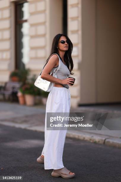 Anna Winter wearing Balenciaga x Crocs Pool Slide beige Sandal, Source Unknown white loose pants, Source Unknown silver shiny hobo bag, Balenciaga...