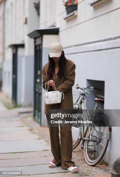 Anna Winter wearing Birkenstock white sandals, LalaBerlin matching olive suit with loose pants and statement oversized blazer, Bottega Veneta Arco...