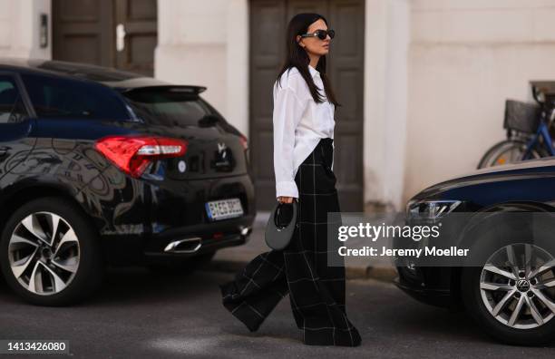 Anna Winter wearing Celine round black shades, Filippa K white oversized statement blouse, Coperni black mini leather bag, Joseph checked black grey...