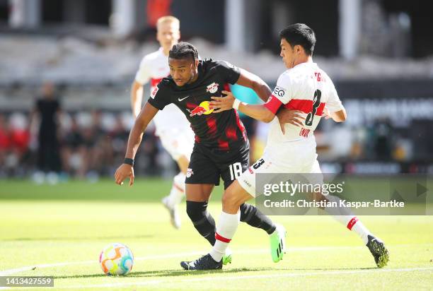 Christopher Nkunku of RB Leipzig is challenged by Wataru Endo of VfB Stuttgart during the Bundesliga match between VfB Stuttgart and RB Leipzig at...