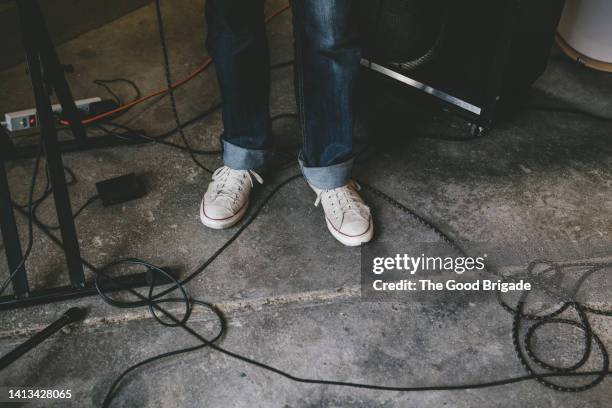 low section of musician wearing sneakers standing by cables - unterer teil stock-fotos und bilder