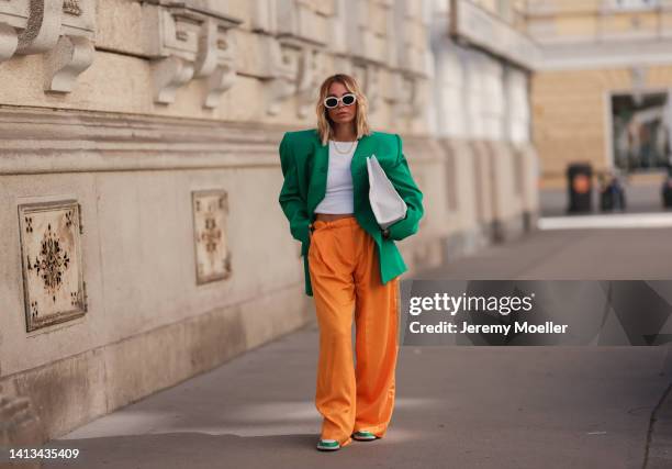 Karin Teigl wearing Celine white round shades, Balenciaga green shoulder pads blazer, CYK by constantly k white cropped top, COS orange wide leg...