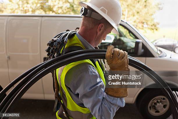 cable installer carrying video cables from a truck - cable installation stock pictures, royalty-free photos & images