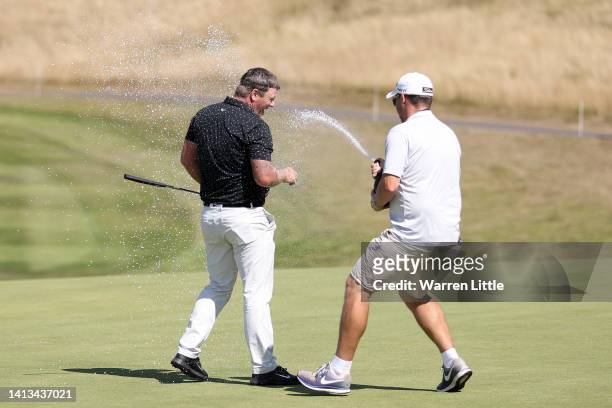 Callum Shinkwin of England is sprayed with champagne by a caddy after defeating Connor Syme of Scotland to win the Cazoo Open during day four of the...