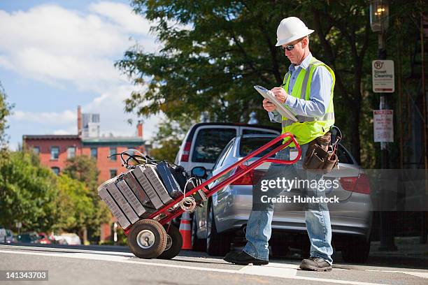 cable installer with hand truck full of set-top boxes in the city logging data - electronic logging stock pictures, royalty-free photos & images