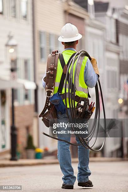 cable installer carrying video cables on a street - cable installer stock pictures, royalty-free photos & images