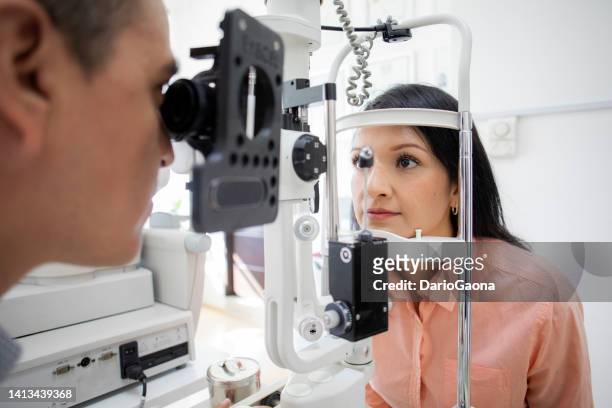 oculist examining female patient - eye test stock pictures, royalty-free photos & images