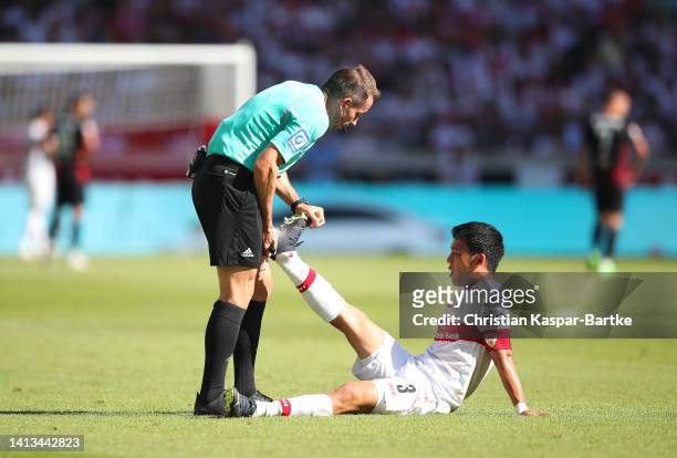 Referee, Tobias Stieler gives medical treatment to Wataru Endo of VfB Stuttgart during the Bundesliga match between VfB Stuttgart and RB Leipzig at...